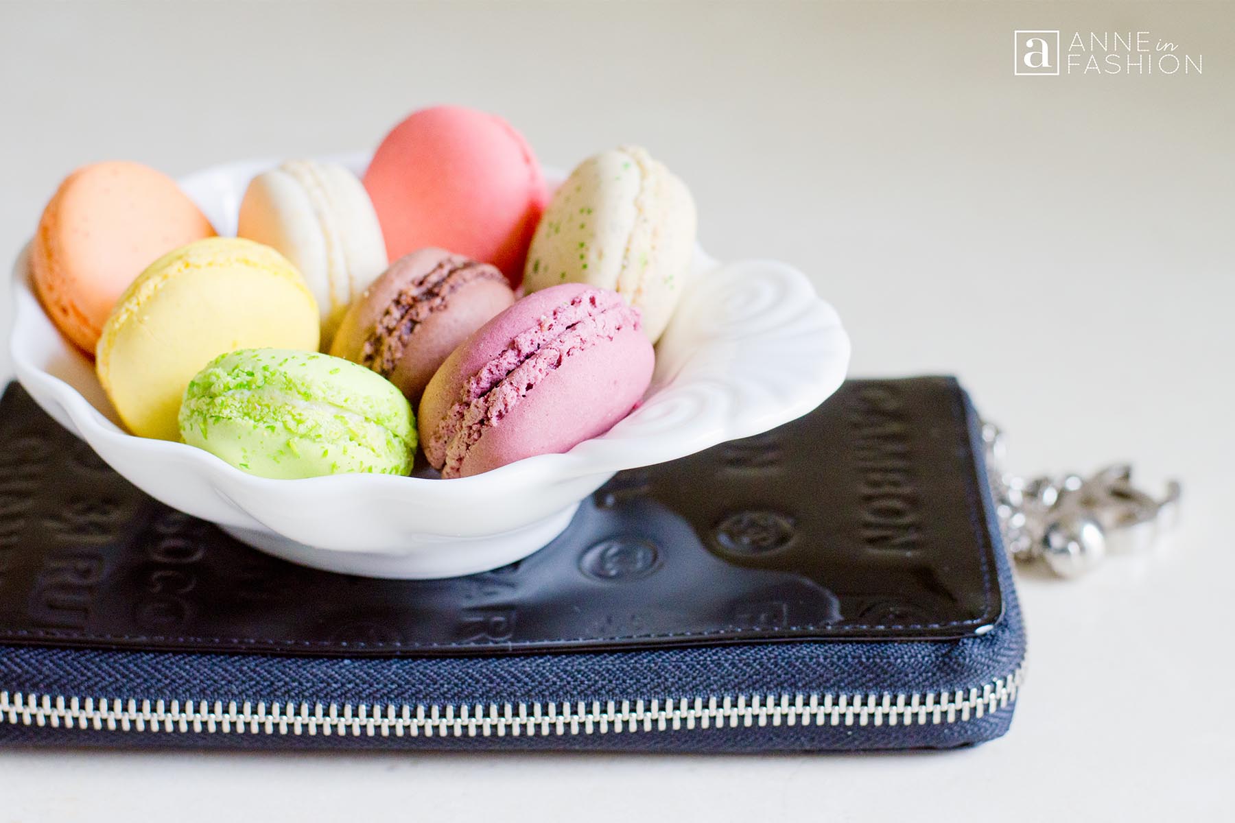 French macarons in dish with Chanel clutch wallet bag